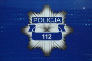 odznaka policyjna umieszczona na niebieskim tle na dole numer alarmowy 112