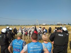 Zdjęcie przedstawia policjanta wchodzącego w skład zespołu anty-konfliktowego KWP w Poznaniu  ubranego w kamizelkę koloru niebieskiego