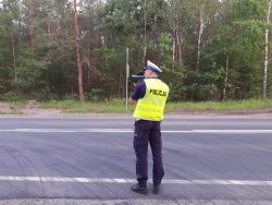 Policjant dokonuje pomiaru prędkości kierujących przy użyciu laserowego miernika prędkości