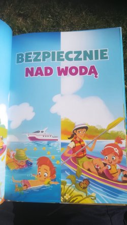 Ilustracja książki na niej dzieci bawiące się w wodzie i hasło bezpiecznie nad wodą